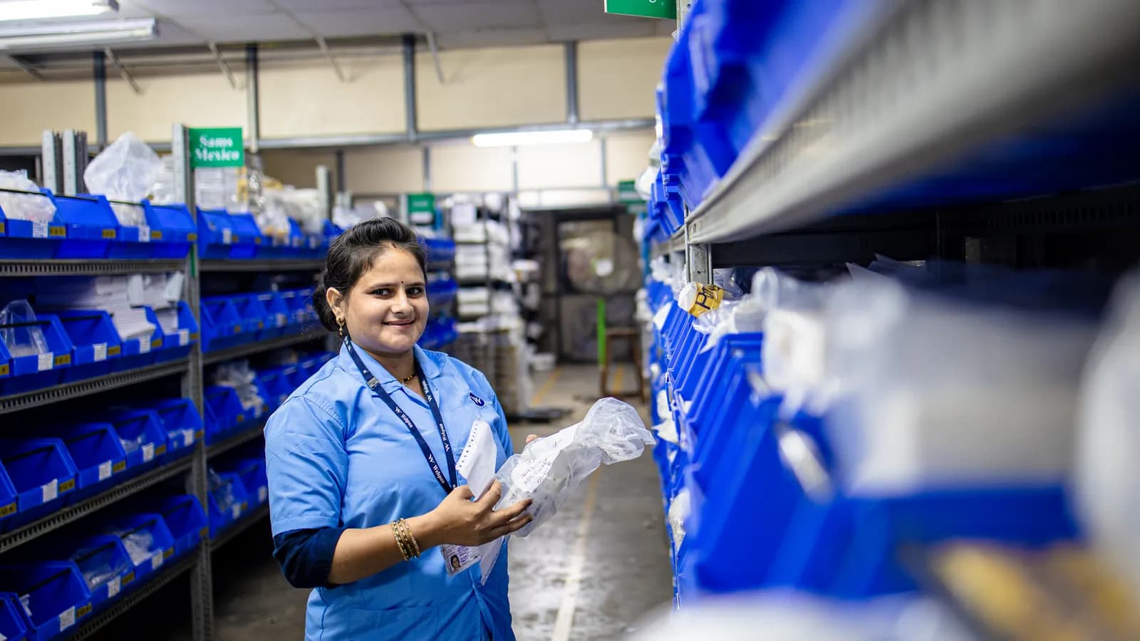 Inventory manager organising labelled bins in a warehouse